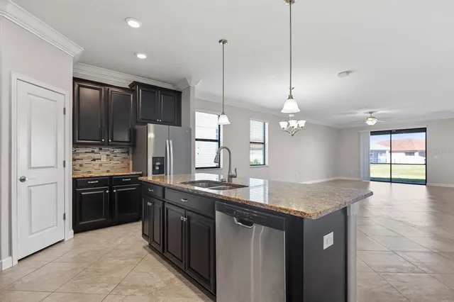 a kitchen with stainless steel appliances granite countertop a sink a stove and a wooden floors