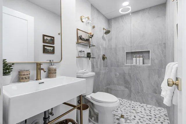 a bathroom with a sink a toilet and shower