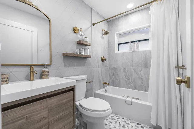 a bathroom with a sink toilet vanity and shower