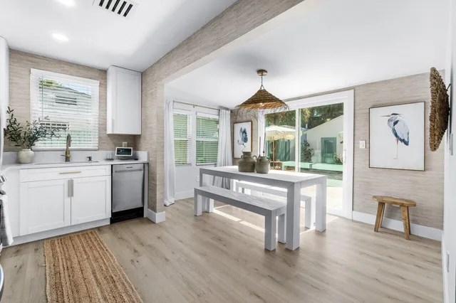 a open kitchen with white cabinets and wooden floor