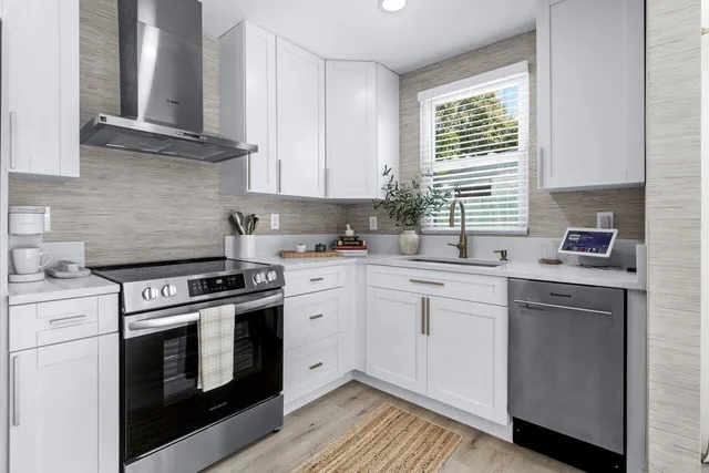 a kitchen with cabinets stainless steel appliances a sink and wooden floor