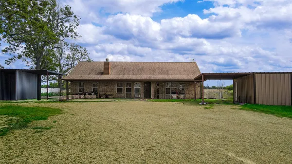 a view of a house with a yard and sitting area