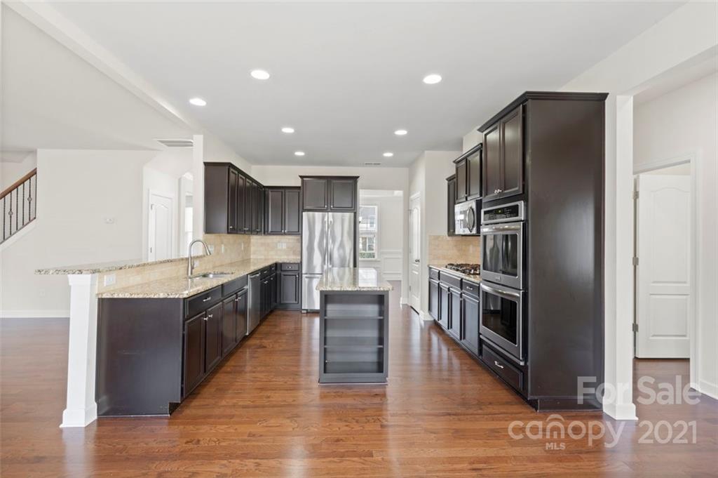 4331 Oxford Mill Road Waxhaw, NC 28173 - Photo 12 of 48 a large kitchen with stainless steel appliances granite countertop a stove and a refrigerator