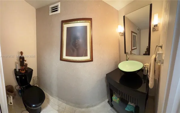 a bathroom with a toilet mirror and vanity