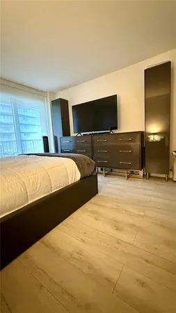 a bedroom with a bed and a television