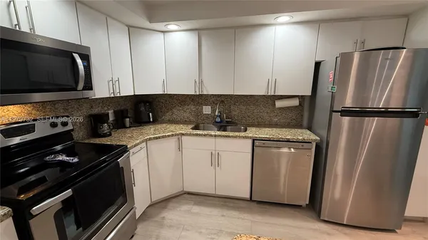 a kitchen with stainless steel appliances a refrigerator stove and microwave