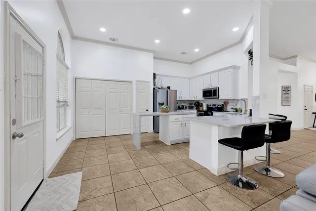 a kitchen with stainless steel appliances kitchen island granite countertop a refrigerator and a stove top oven