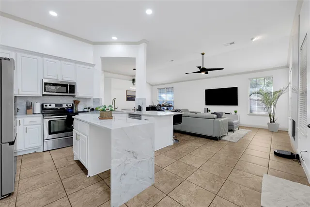 a kitchen with stainless steel appliances a stove a sink a microwave and a refrigerator