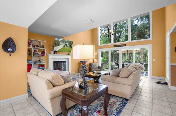 a living room with furniture a fireplace and a large window
