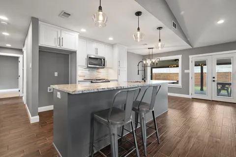 a view of a kitchen with a sink and wooden floor