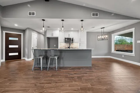 a view of kitchen with kitchen island a window and chairs