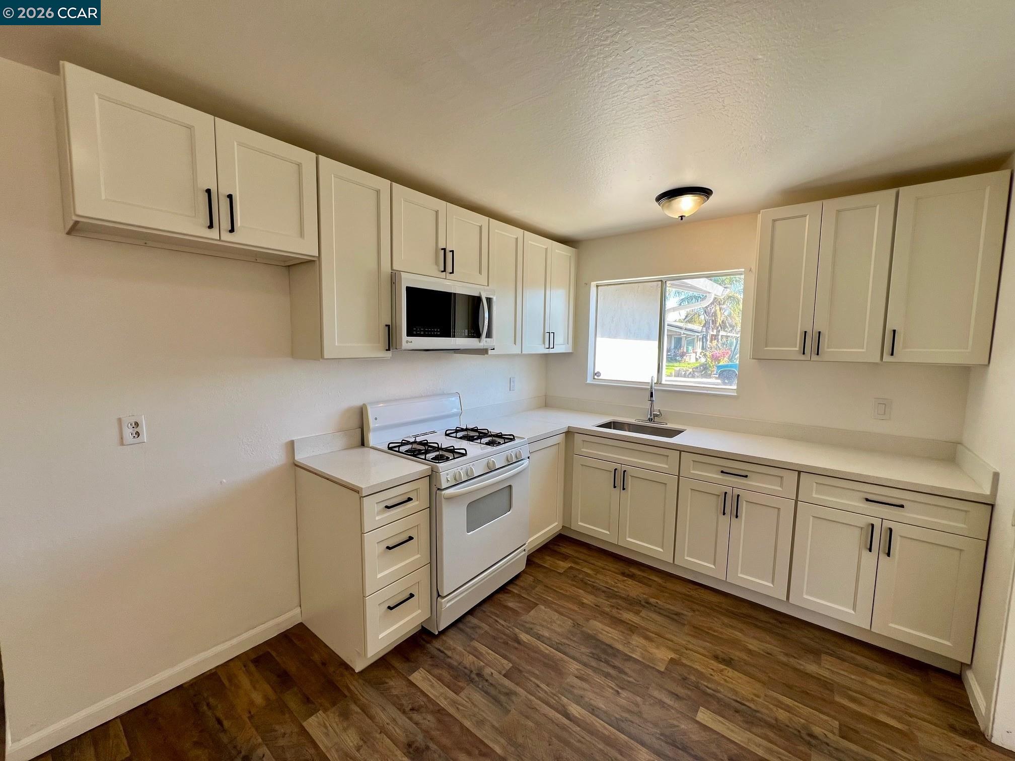29 Sandview Drive Bay Point, CA 94565 - Photo 5 of 26 a kitchen with cabinets wooden floor and a window