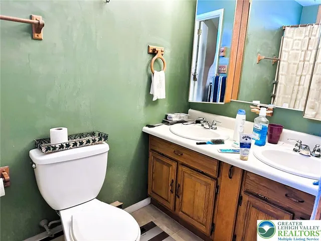 a bathroom with a toilet sink and mirror