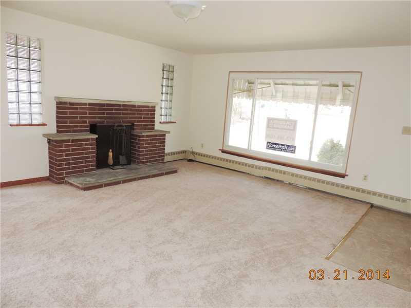 Living Room. The spacious living room is bathed in natural light and features a lovely logburning fireplace, brand new crpeting and fresh paint