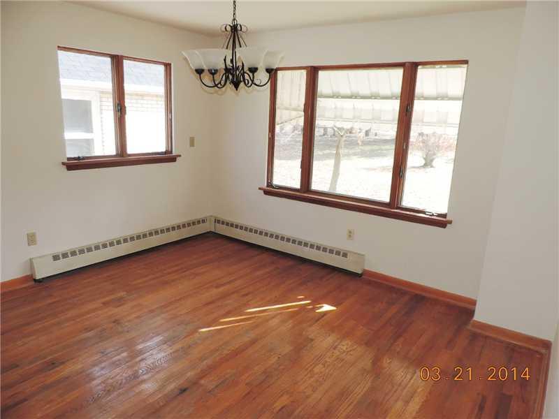 Dining Room. The dining room shows the original hardwood floors and attractive chandelier. It too has been freshly painted