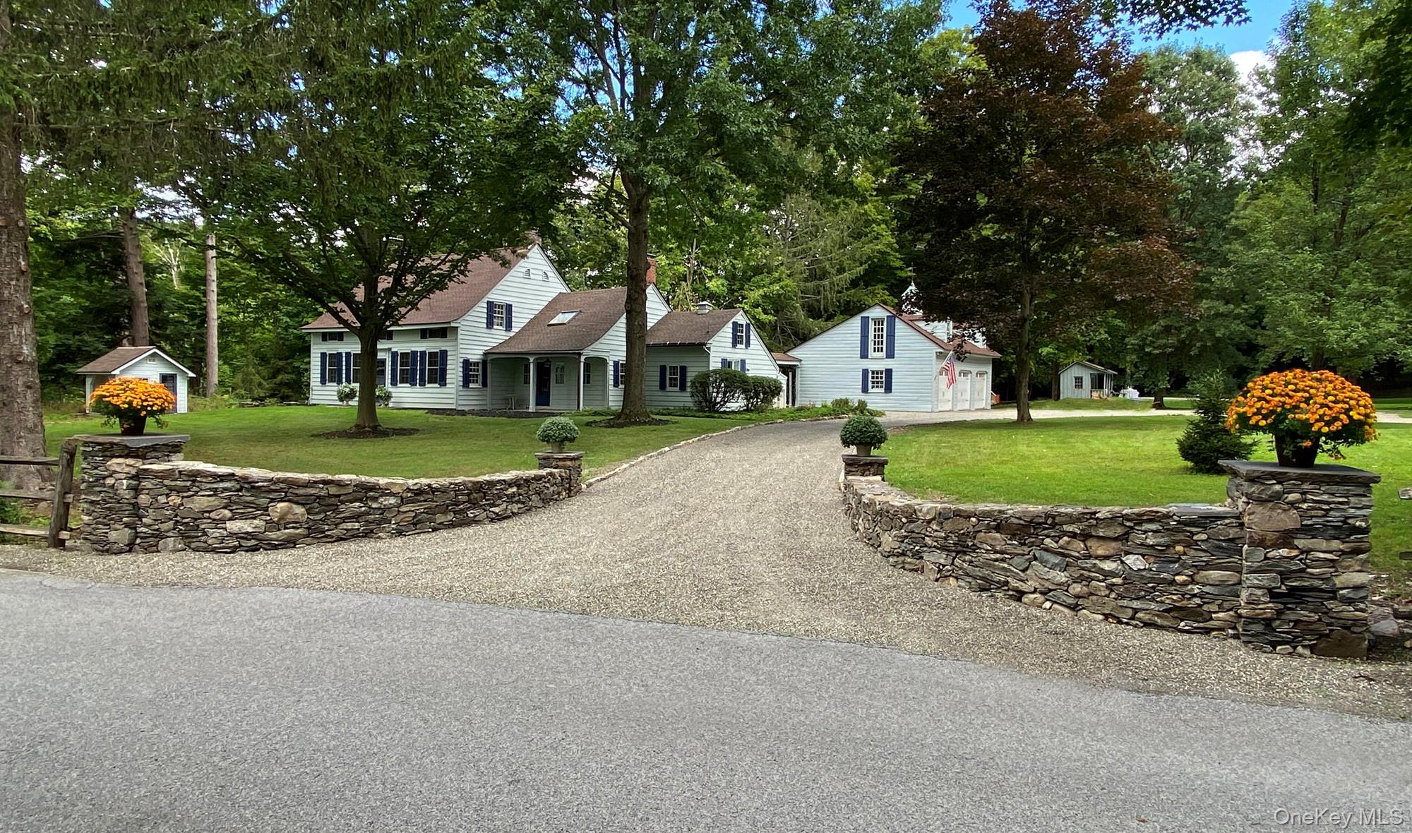 a front view of a house with a garden and trees