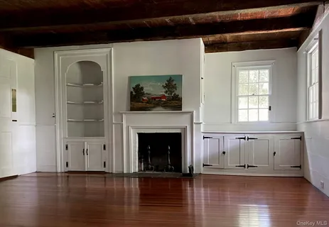 a view of a livingroom with wooden floor and a fireplace