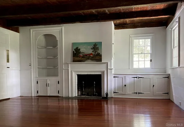 a view of a livingroom with wooden floor and a fireplace
