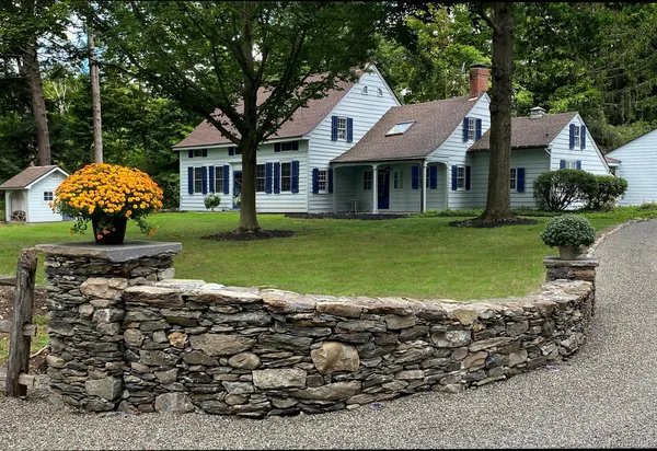a front view of a house with a garden and trees