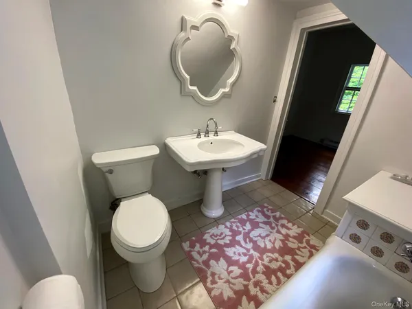 a bathroom with a toilet a sink and mirror