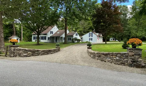 a front view of a house with a garden and trees