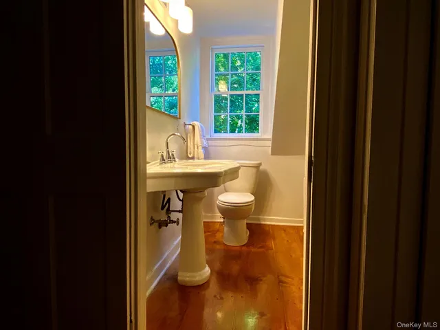 a bathroom with a sink toilet and a mirror