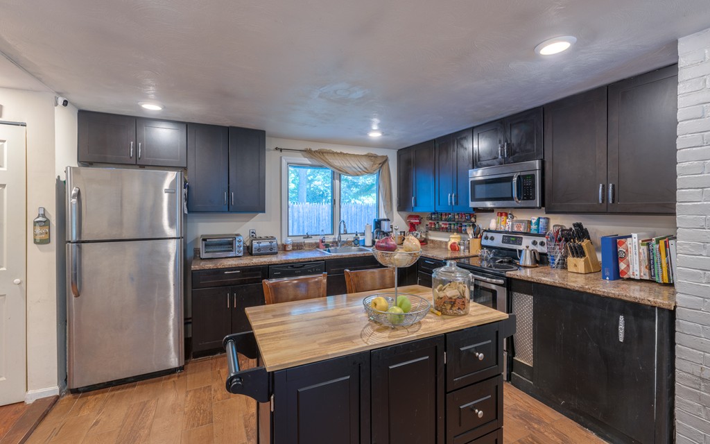 40 Christopher Road Brockton, MA 02302 - Photo 8 of 27 a kitchen with a refrigerator a stove a sink dishwasher and wooden cabinets with wooden floor