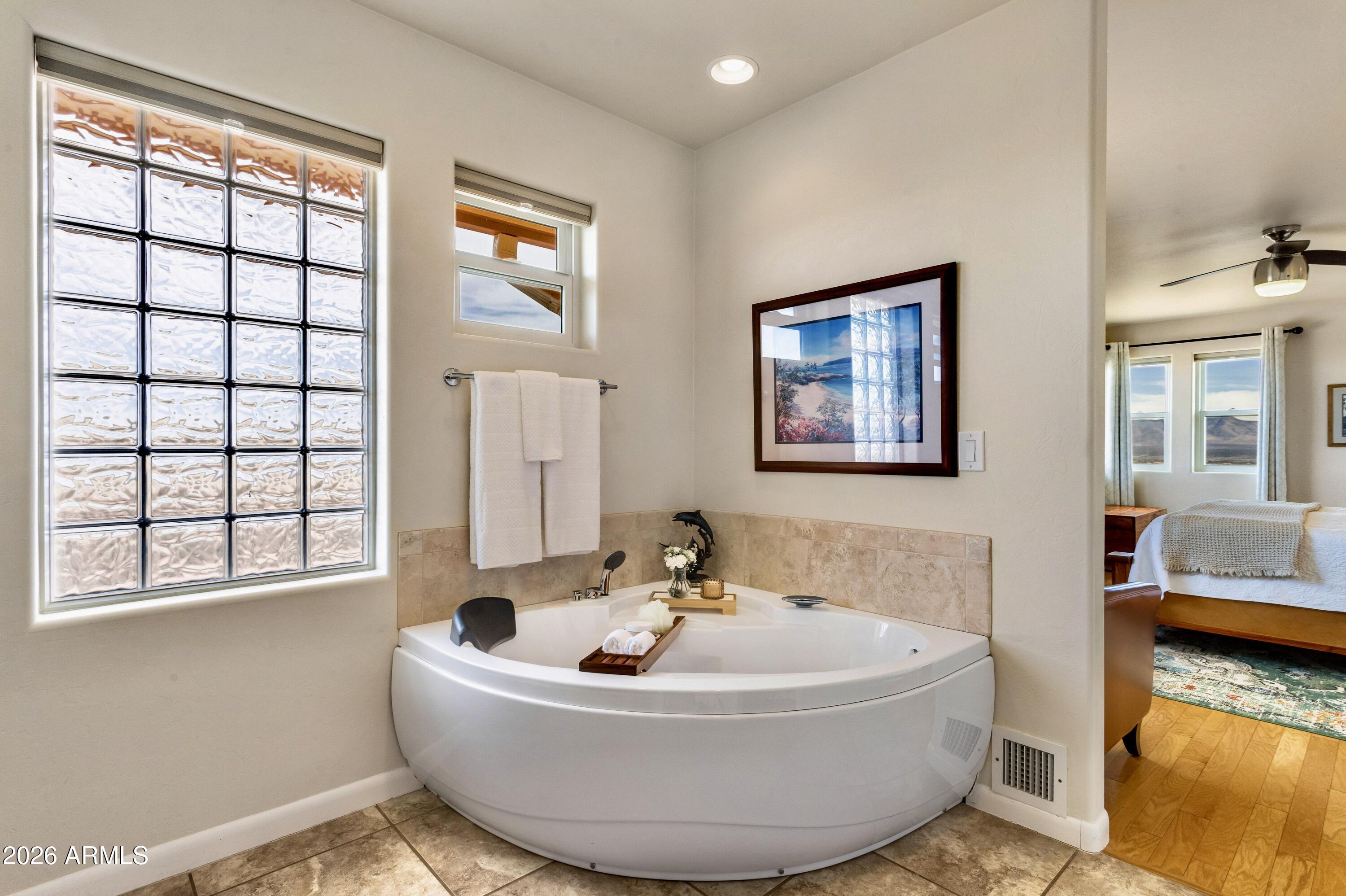 8541 South Almosta Ranch Road Hereford, AZ 85615 - Photo 30 of 53 a white bath tub sitting in a bathroom next to a window