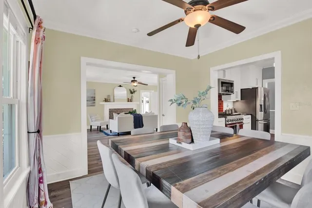a dining room with wooden floor and chandelier