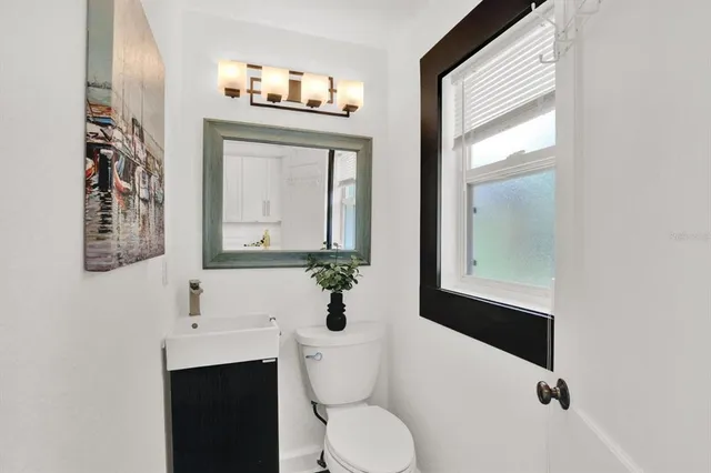 a bathroom with a toilet sink and mirror