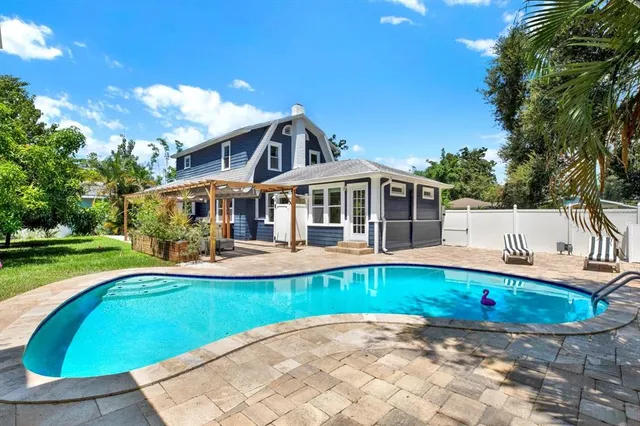 a view of a house with swimming pool and a yard
