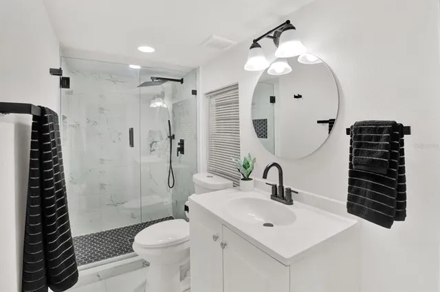 a bathroom with a sink a toilet and shower