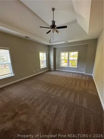 en empty room with windows and ceiling fan