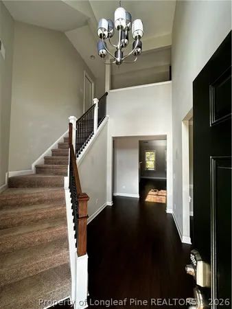 a view of a hallway with wooden floor windows and a chandelier