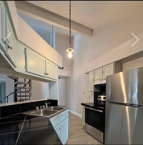 a kitchen with stainless steel appliances granite countertop a refrigerator a stove a sink and a refrigerator