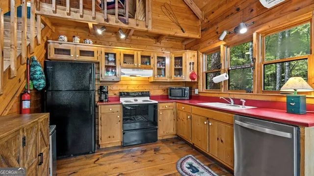 a kitchen with stainless steel appliances granite countertop a sink and a refrigerator