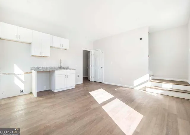 a view of kitchen with granite countertop cabinets and sink