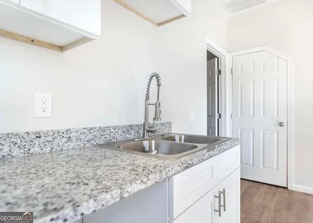 a bathroom with a granite countertop sink and a mirror
