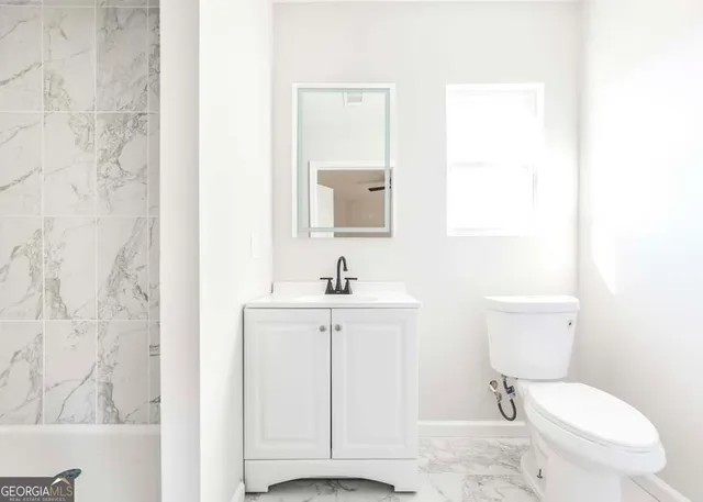 a white toilet sitting next to a bathroom sink