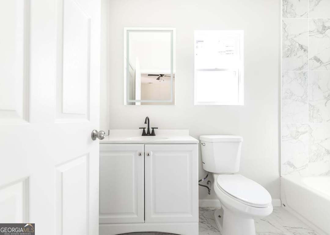 114 Emily Street Macon, GA 31204 - Photo 20 of 24 a bathroom with a toilet a sink a mirror and a window