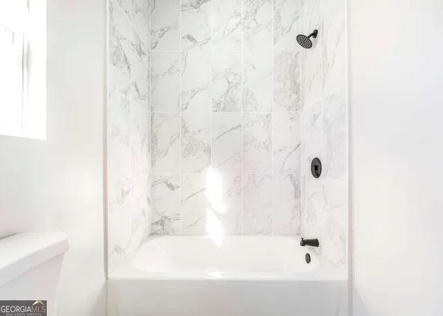 a bathroom with a bathtub and shower