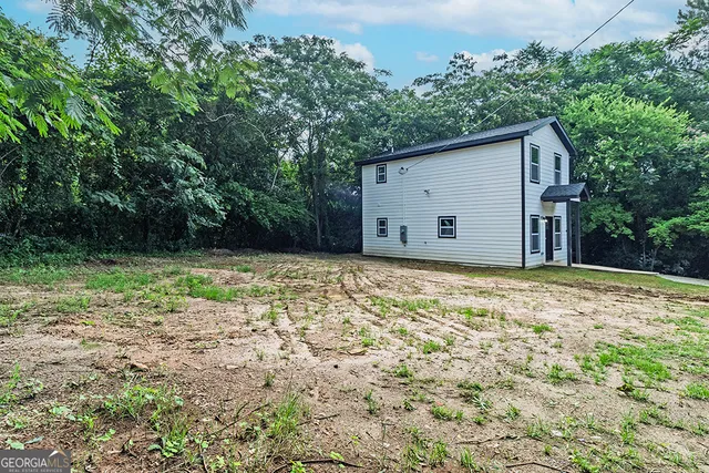 a view of a house with backyard and tree