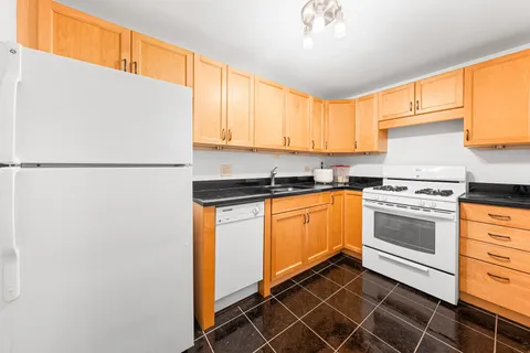 a kitchen with a refrigerator sink and cabinets