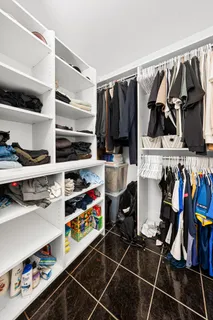 a view of walk in closet with clothes and shoes