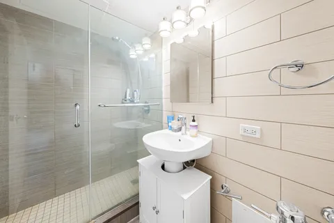 a bathroom with a sink a toilet a mirror and shower