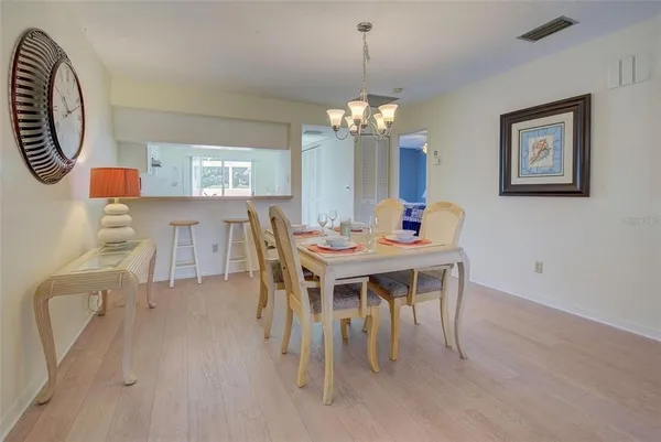 a dining room with furniture a chandelier and wooden floor