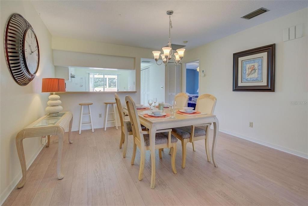 314 Cerromar Way, Unit 16 Venice, FL 34293 - Photo 11 of 47 a dining room with furniture a chandelier and wooden floor