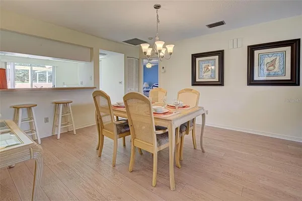 a dining room with furniture a chandelier and wooden floor
