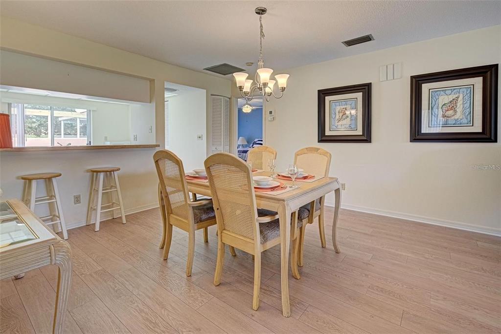 314 Cerromar Way, Unit 16 Venice, FL 34293 - Photo 12 of 47 a dining room with furniture a chandelier and wooden floor