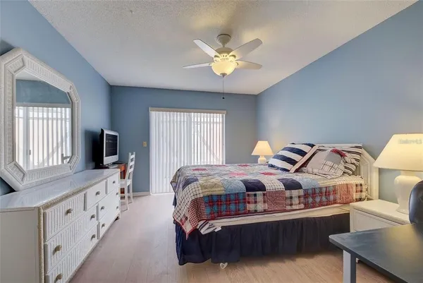 a spacious bedroom with a bed and a chandelier